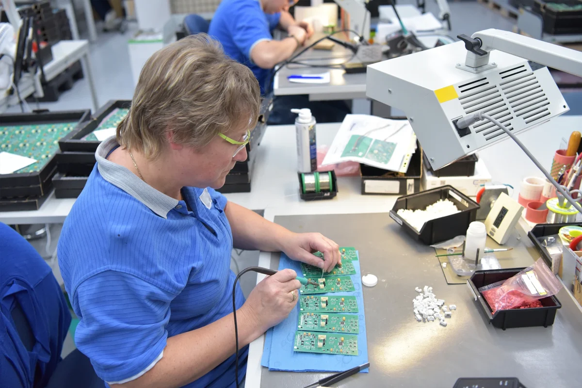 friendly woman working in a microelectronics manufacturing factory - component assembly and soldering