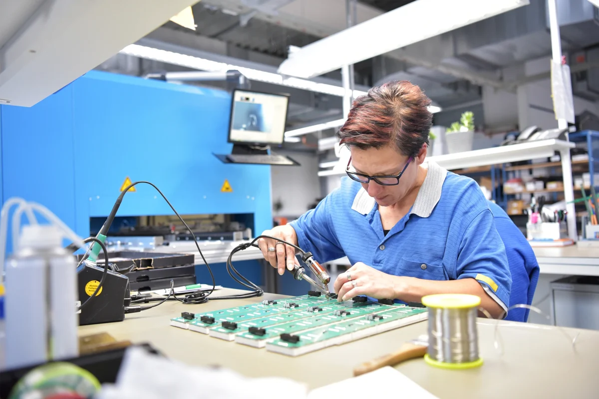 friendly woman working in a microelectronics manufacturing factory - component assembly and soldering